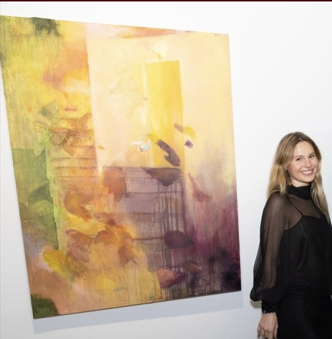Roxana Kaplan, founder of Ōnder Ōns, standing beside an abstract painting